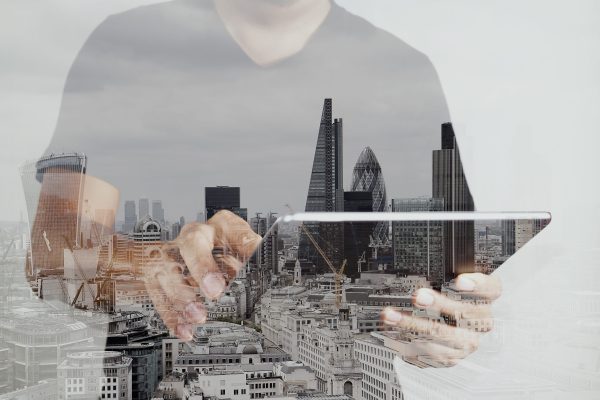 Double exposure of success businessman using digital tablet with london building and social media diagram